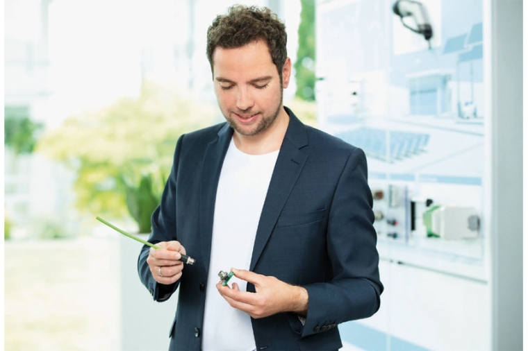 Tim Kindermann, Phoenix Contact, zeigt den SPE M12-Rundsteckverbinder, der in...