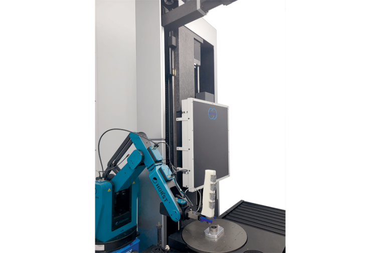 Ein Roboter bestückt ein CT-Messgerät durch Aufnahme eines vor der Maschine...