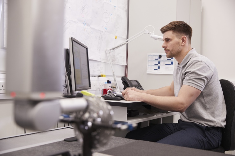 QC specialists working on a CMM in the lab