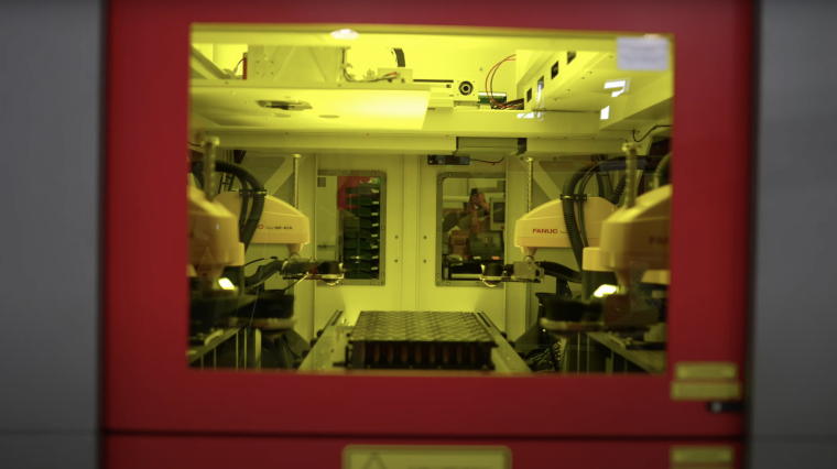 Inside the housing, four Scara robots sequentially clamp and connect the...