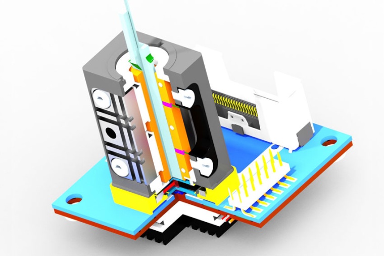 The VCSEL source on the ceramic printed circuit board (PCB) is shown with the...