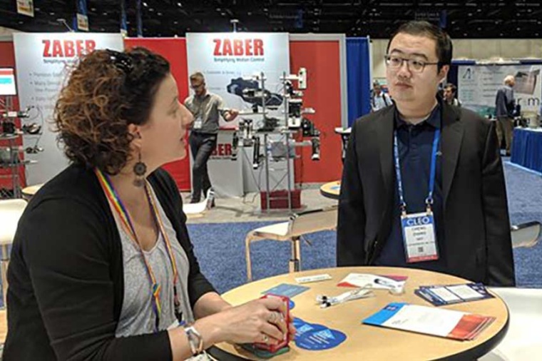 Conference attendees visit the Optica booth at a CLEO meeting. (Source: Optica)