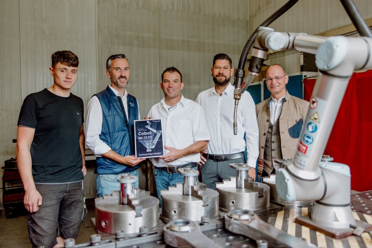 Andreas Mayrs team with the anniversary cobot. Image: UR