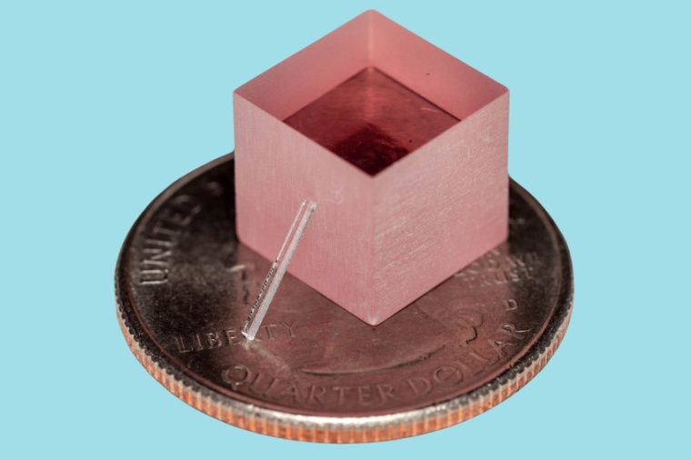 The new laser leans against a block of titanium-sapphire. For scale, both sit...
